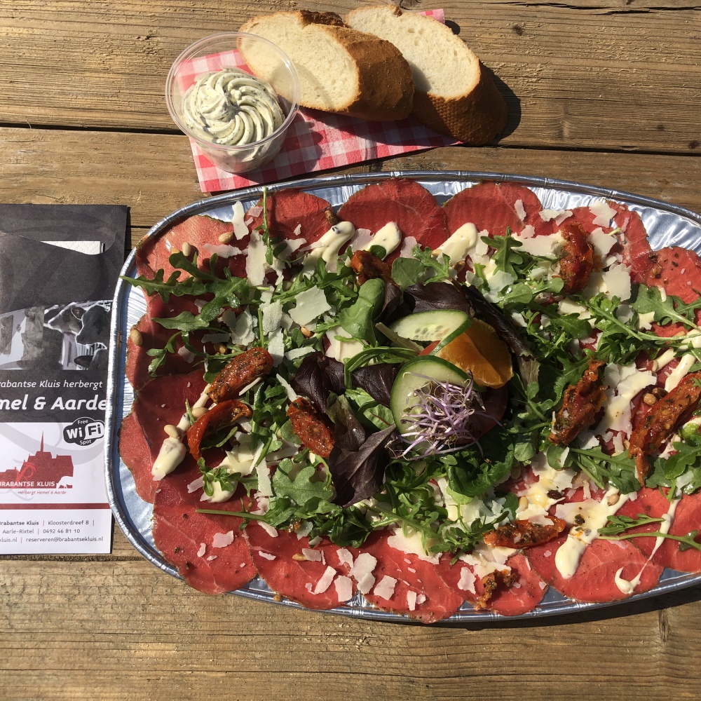 Carpaccio XL of rush beef with Parmesan cheese, pine nuts and green saled, served with pestodressing